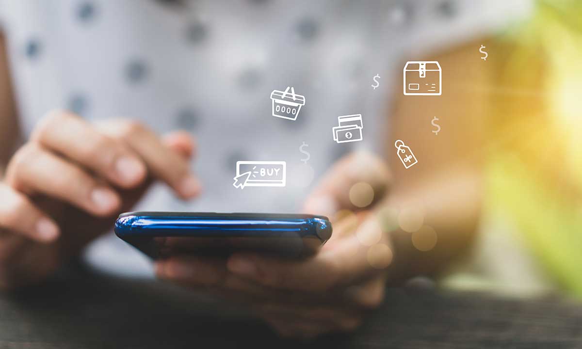 Person using a smartphone with digital icons floating above, symbolizing online shopping actions like 'Buy' and payment options, showcasing the interactive nature of modern e-commerce.